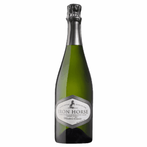 A green bottle of Iron Horse sparkling wine with a silver foil top and white label on a plain background.