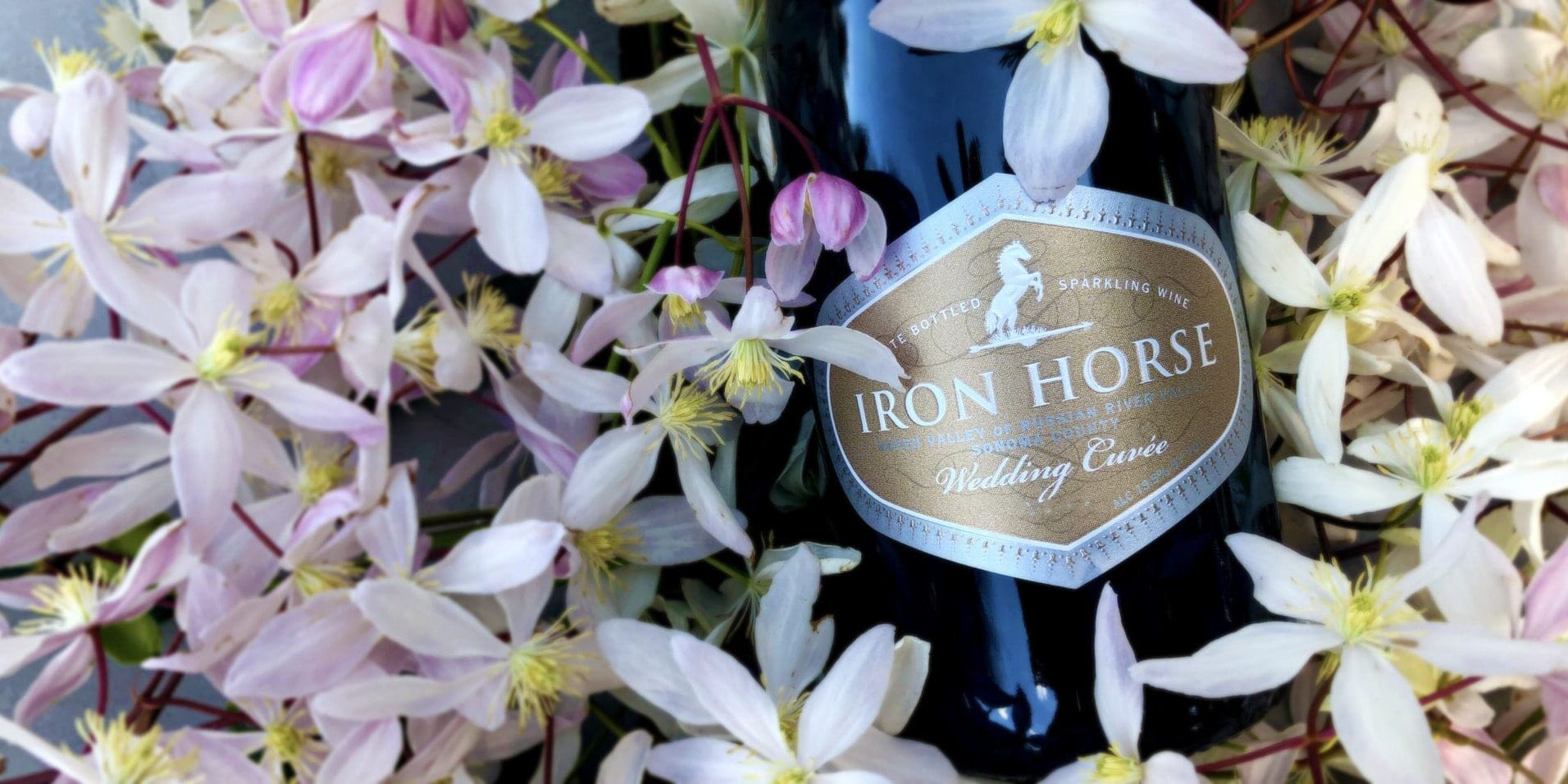 a bottle of wedding cuvee on a bed of white flowers