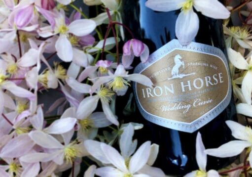 a bottle of wedding cuvee on a bed of white flowers